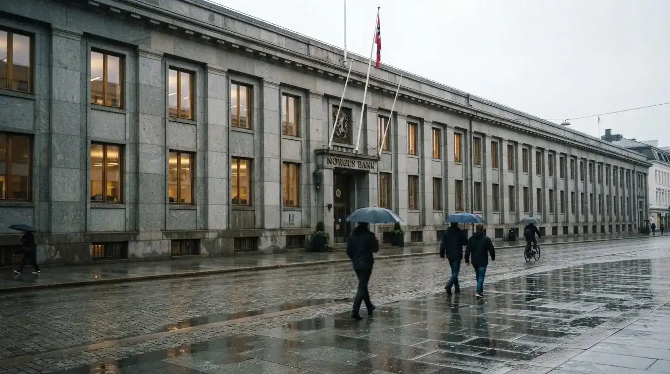 Lav bankbygning i stein med store vinduer i regnvær, folk med paraplyer foran